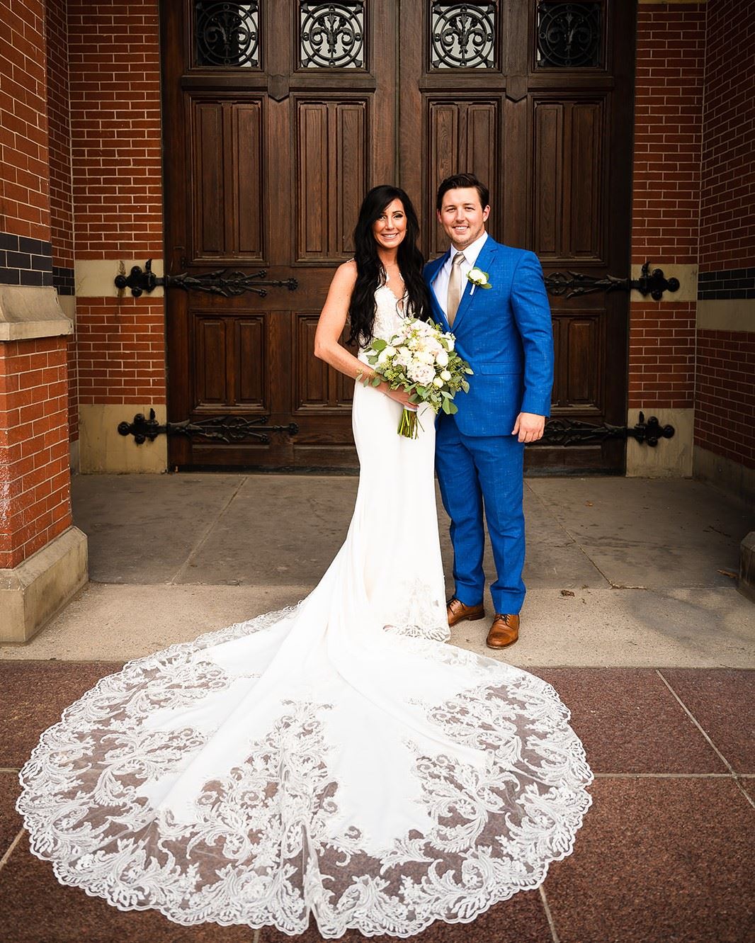 bride and groom standing in front of wedding venue