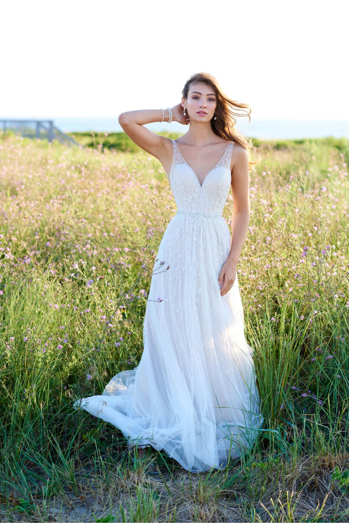 Brunette model in field wearing wedding dress