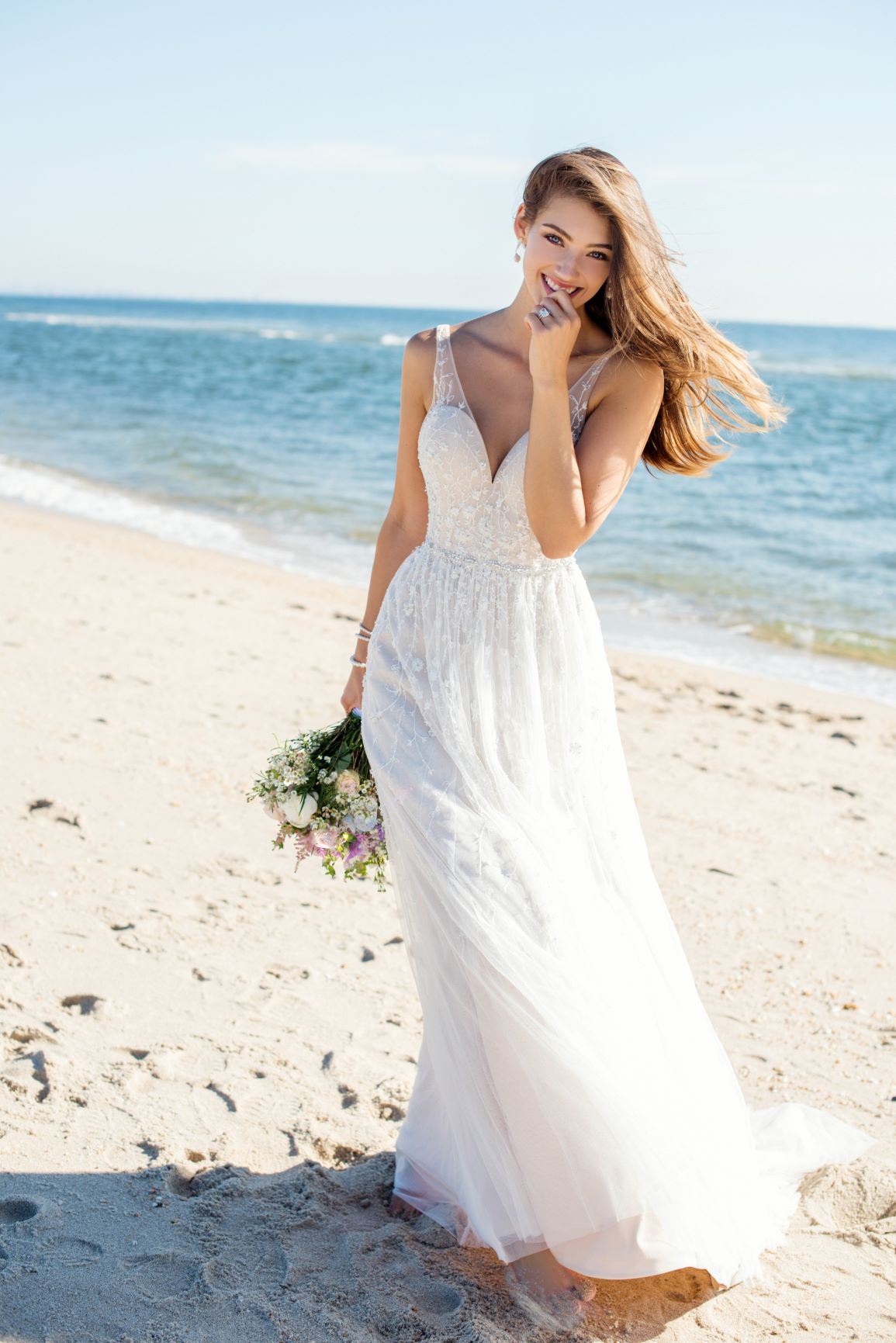 Brunette bride smiling at the beach