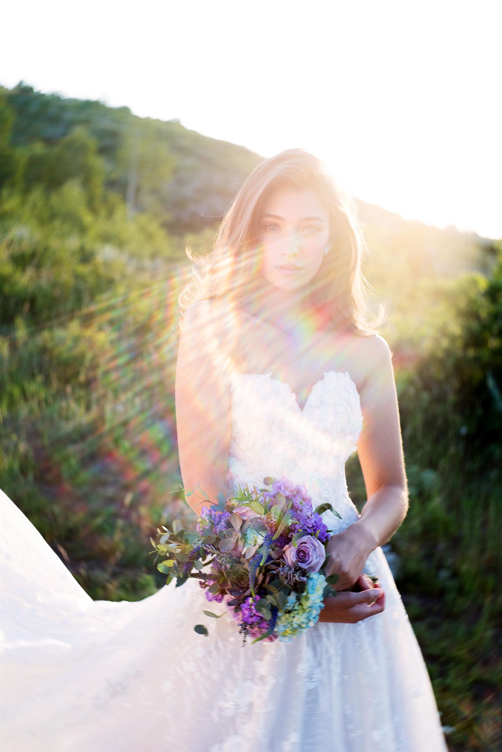 Brunette bride in strapless wedding dress holding flowers